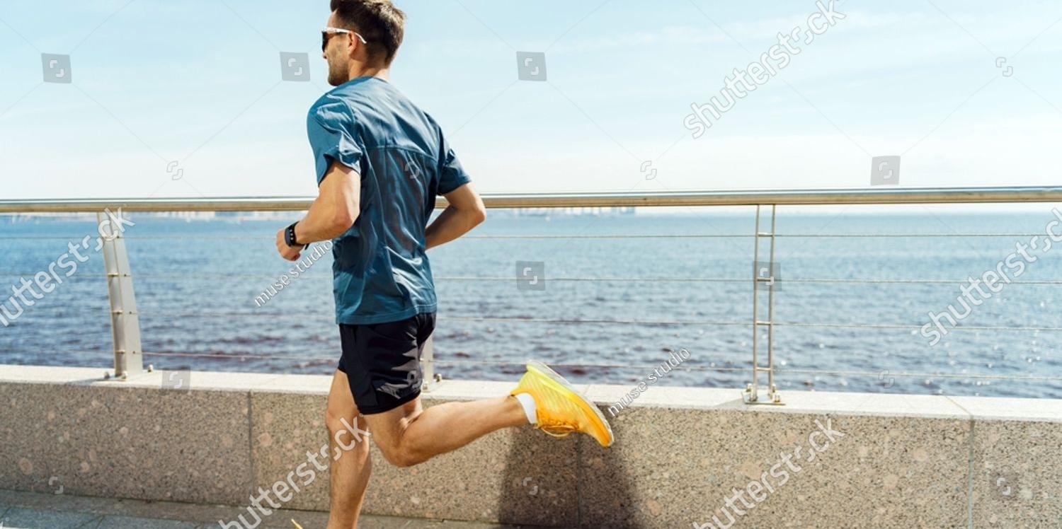 A man running along a seaside promenade